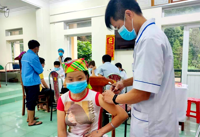 Cán bộ Trung tâm Y tế huyện Mù Cang Chải tiêm vắc xin Covid-19 cho người dân. 
